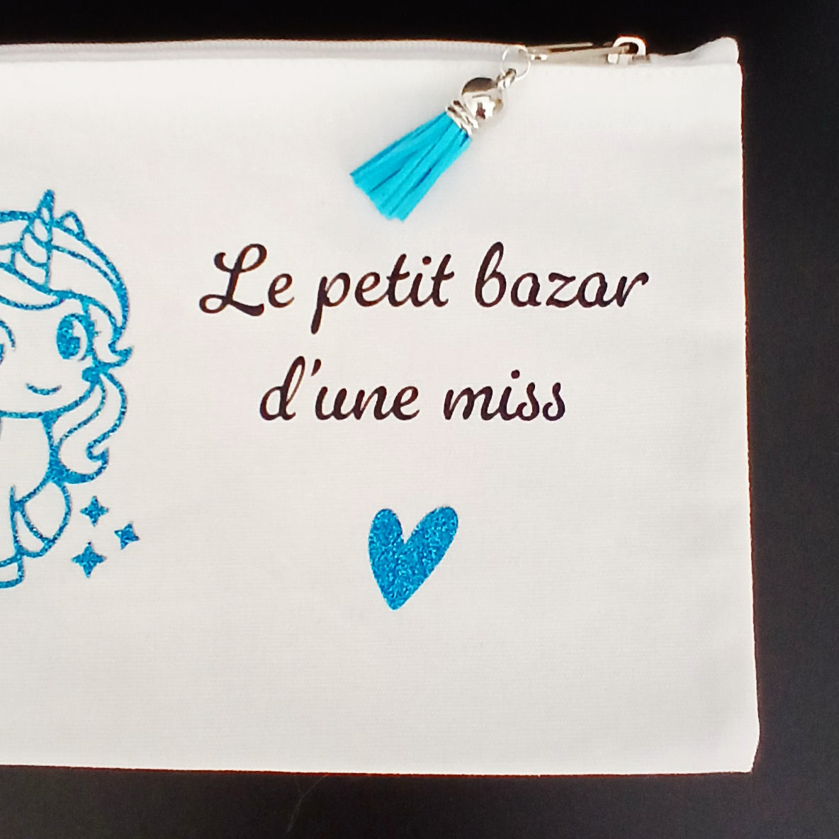 Trousse sublimée "le petit bazar d'une miss" avec une licorne turquoise.